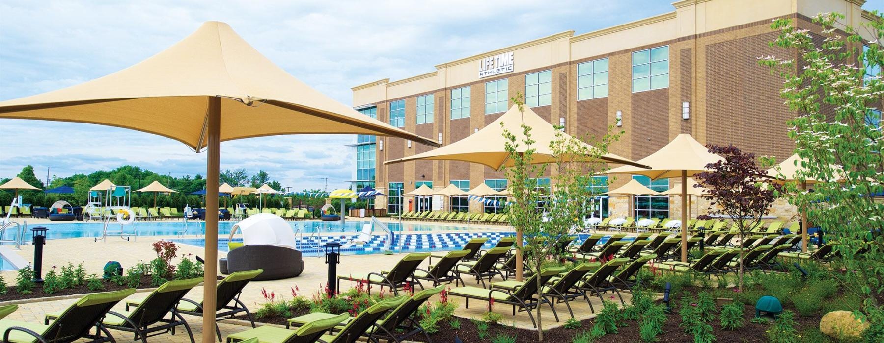 a building with a pool and chairs