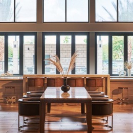 a clubroom with tables, chairs and large windows